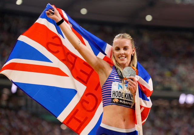 Keely Hodgkinson holds up a Union Jack flag as she shows off her silver medal