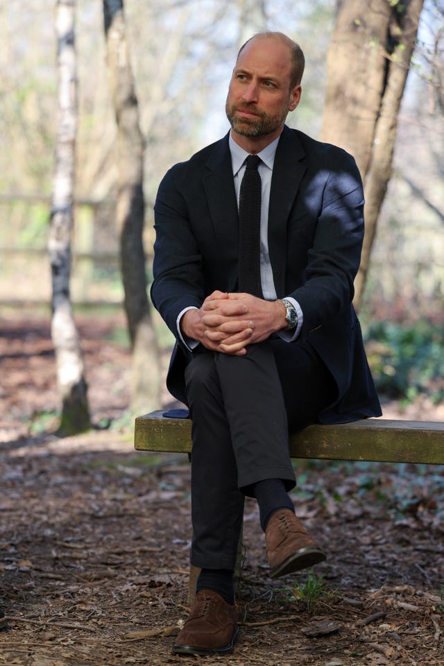 Prince of Wales sitting near a campfire