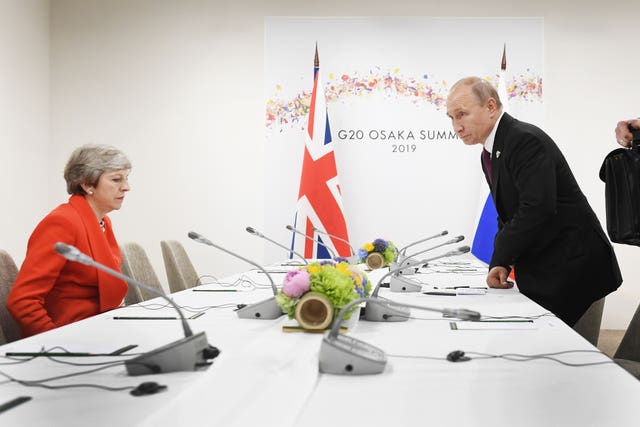 Theresa May and Vladimir Putin take their seats for a meeting together during the G20 summit in Osaka