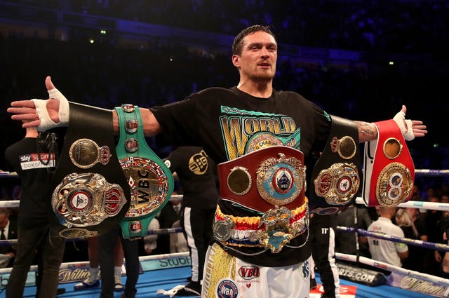 Oleksandr Usyk celebrates with his belts after beating Tony Bellew