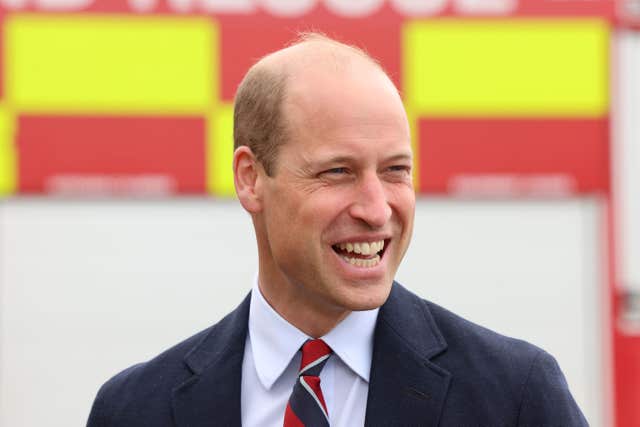 Prince of Wales stands in front of a fire engine