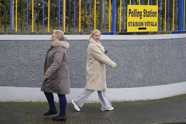 A person walks to a polling station as another person walks in the opposite direction