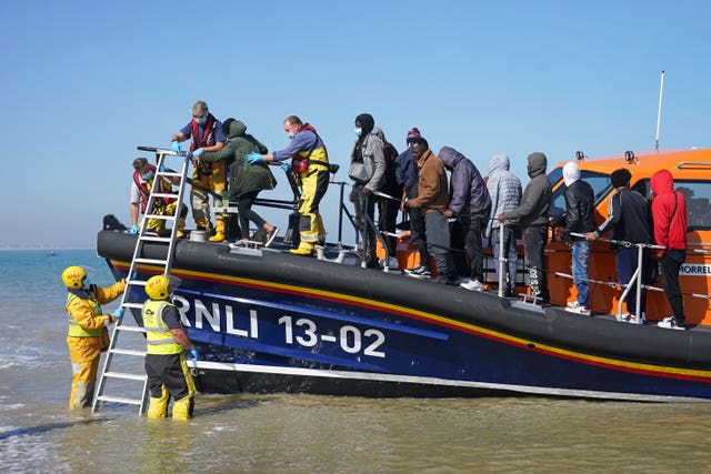 A group of people thought to be migrants are brought ashore from the local lifeboat at Dungeness in Kent