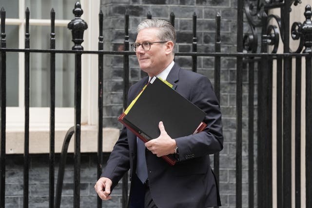 Prime Minister Sir Keir Starmer walking with a folder under his arm 