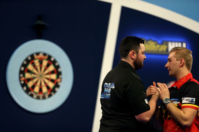 Luke Humphries (left) consoles Dimitri Van den Bergh after his victory