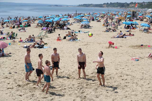 Playing in the hot weather on Bournemouth Beach, in Dorset (Andrew Matthews/PA)