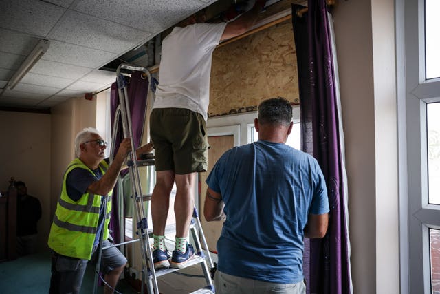 Three men repairing a window