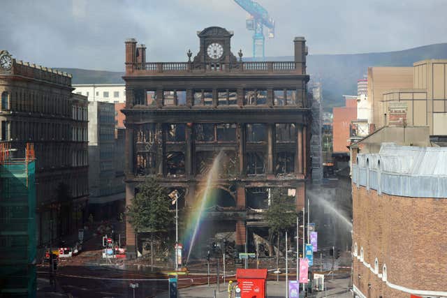 Fire hoses spray water to dampen burning embers inside the Primark store in Belfast