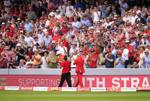 Sir Andrew Strauss, wearing red in support of the Ruth Strauss foundation, is applauded as he walks around the pitch at Lord's