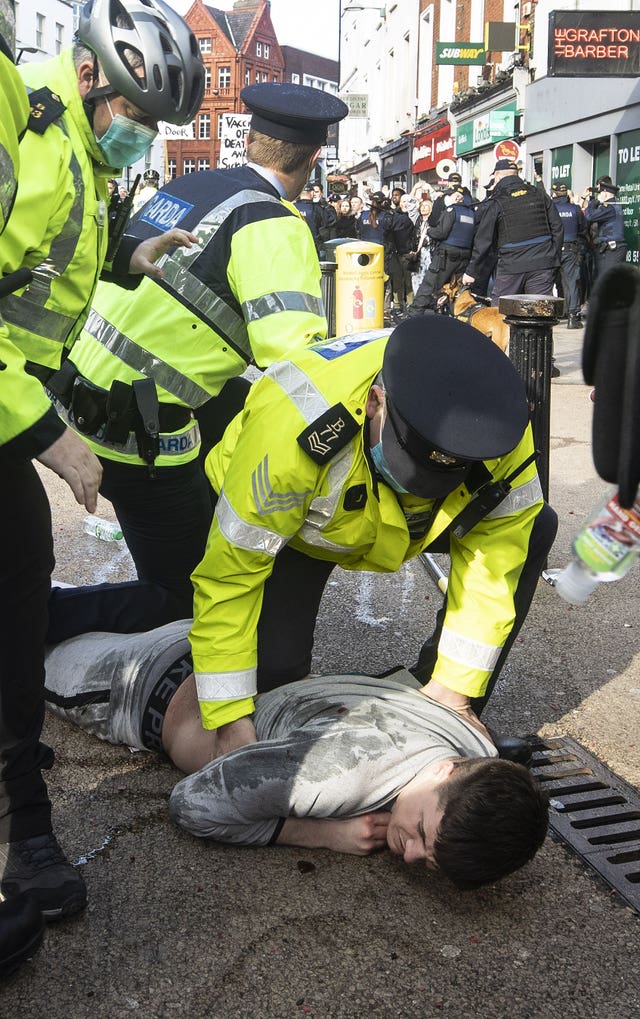 Gardai restrain a protester during an anti-lockdown protest in Dublin city centre