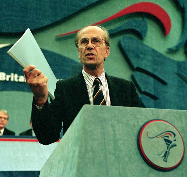 Norman Tebbit holds the Maastricht Treaty up while being watched by John Major at the Conservative Party Conference in Brighton (Adam Butler/PA)