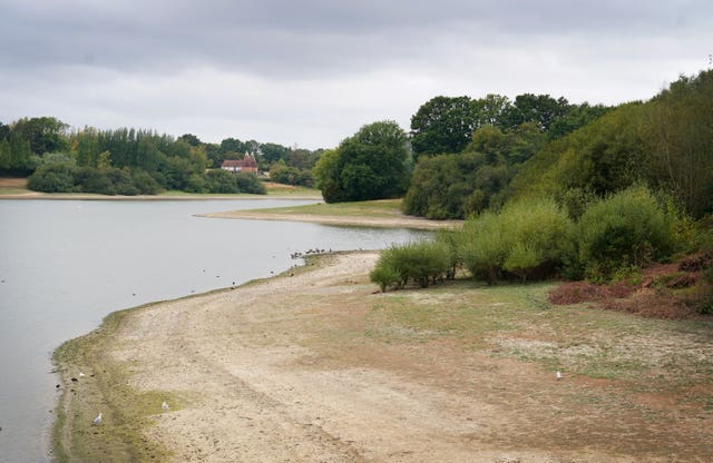 A reservoir with bare ground showing next to low water levels 
