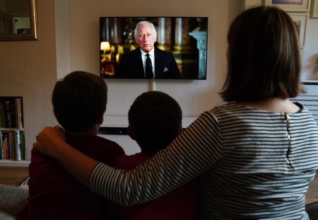 Ben, Isaac and Krystyna Rickett watching a broadcast of the King's first address to the nation 