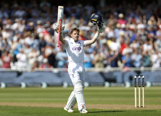 Ollie Pope raises his bat after scoring a hundred against the West Indies