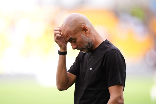Pep Guardiola in deep thought during Manchester City's game at Wolves