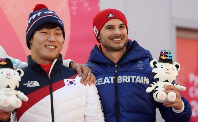 Great Britain’s Dom Parsons celebrates his men's skeleton bronze with South Korea's gold medallist Yun Sung-bin