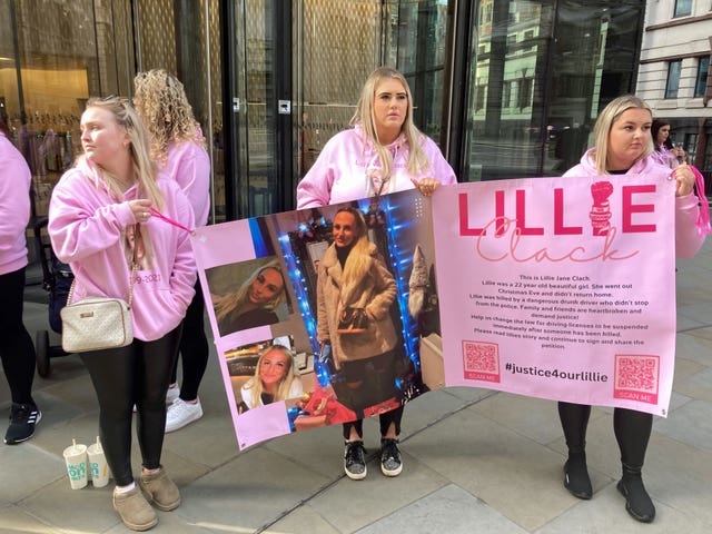 Friends of Lillie Clack, left to right, Kiera Clark, Serena Keogh and Lauren Curson, dressed in pink and holding a poster with pictures of Lillie on it, during a protest outside the Old Bailey in central London