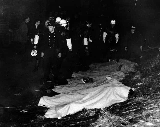 Police and ambulance workers with a line of bodies after the disaster