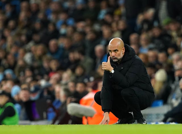 Pep Guardiola gives a thumbs-up gesture on the touchline