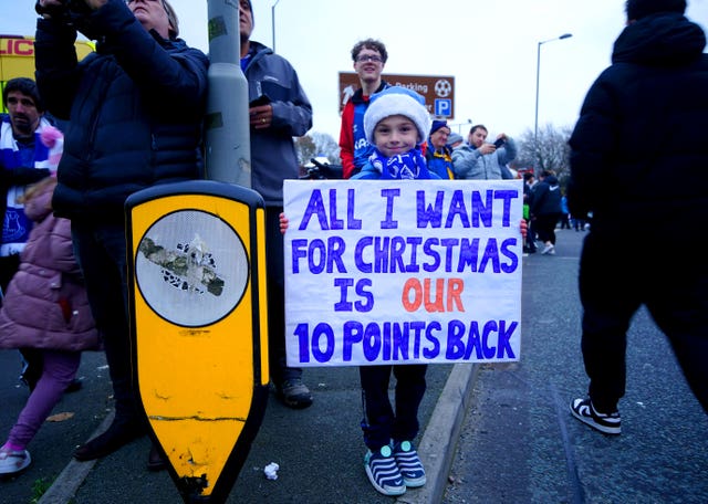 An Everton fan holds up a sign in protest of the club’s original point deduction 