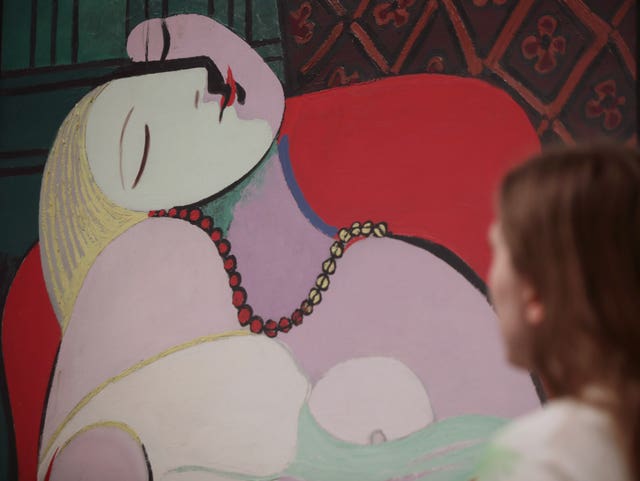 A woman looking at Pablo Picasso’s The Dream, 1932, (Yui Mok/PA)