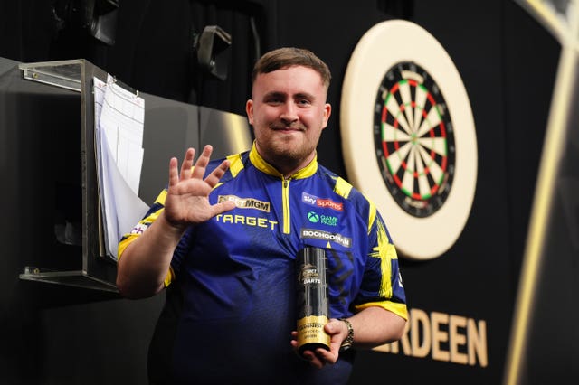 Luke Littler celebrates with the trophy after victory in the final against Luke Humphries on night 13 of the 2026 Premier League in Aberdeen 