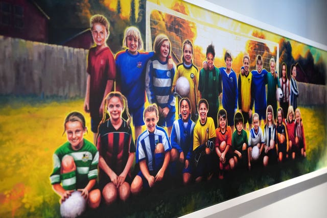 This painting, by Bolton artist Harry Ward, was created from images submitted by each player and shows each in the kit of her grassroots club as a reminder of where they have come from 