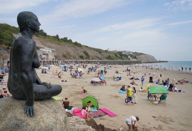People enjoy the warm weather on the beach in Folkestone, Kent, earlier this month