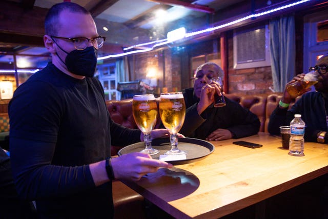 A man carries a tray of drinks to a table at the The Oak Inn in Coventry (Jacob King/PA)