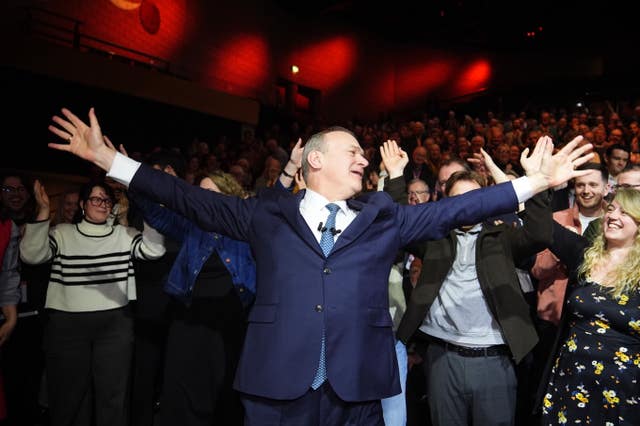Sir Ed Davey with his arms outstretched 