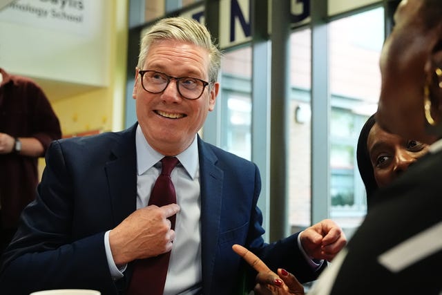 Sir Keir Starmer laughing and pointing at himself