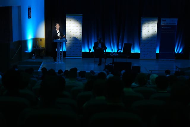 Andy Burnham speaking from a lectern to an audience