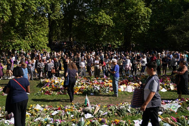 Members of the public view floral tributes in Green Park, near Buckingham Palace.