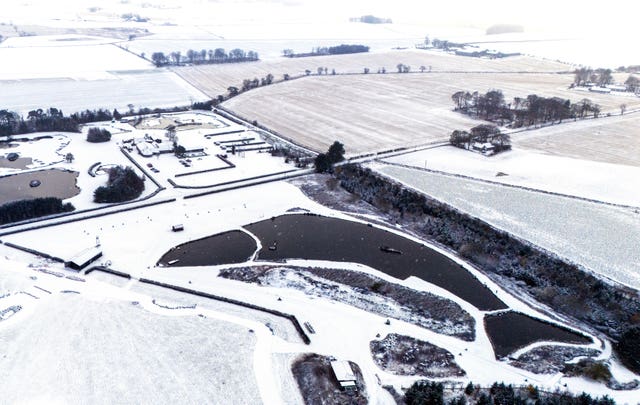 The man-made fish-shaped Muckle Troot Loch near Inverurie, Aberdeenshire, surrounded by snow