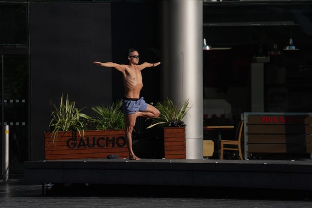 A shirtless man does a yoga poses 