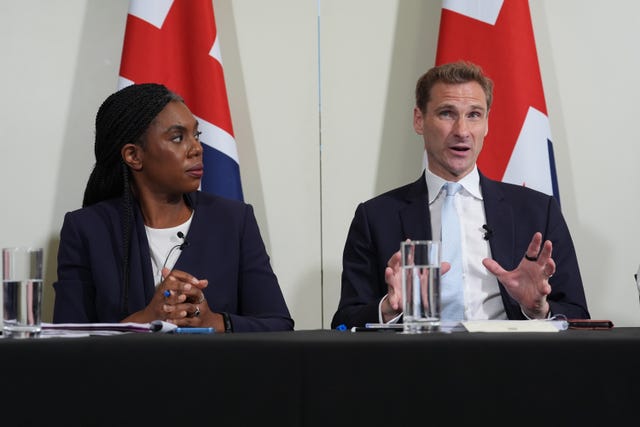 Kemi Badenoch and Chris Philp speak in front of Union flags during a press conference