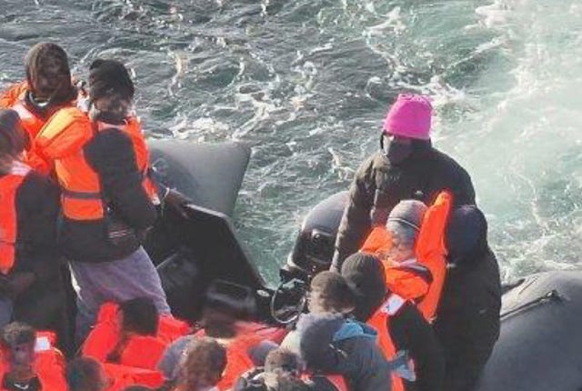 Sudanese national Alnour Ali (pink hat) piloting a small boat on the English Channel 