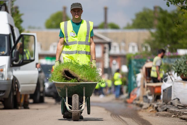 Grass turf being transported in a wheelbarrow, as preparations for the RHS Chelsea Flower Show get under way