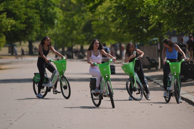 People ride bikes in Hyde Park, London.  