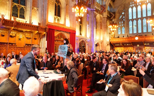 Activists protest during Kemi Badenoch’s speech at the Centre for Policy Studies conference