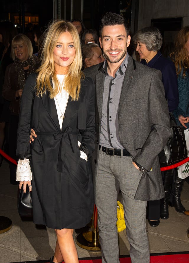 A woman with blonde hair and a dark coat and a man wearing grey trousers and jacket 