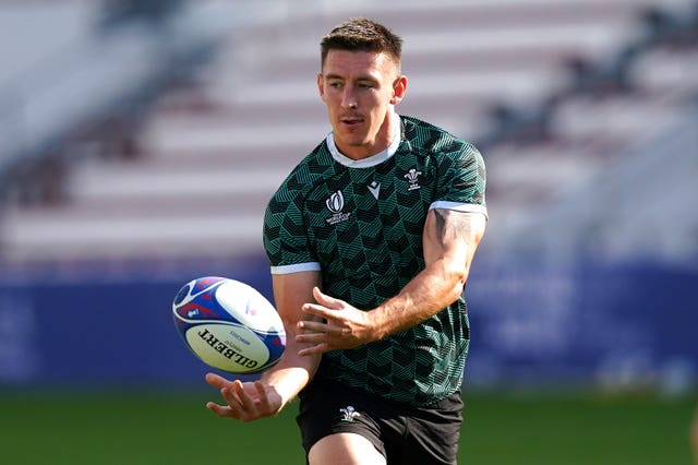 Josh Adams passes the ball during a Wales team run