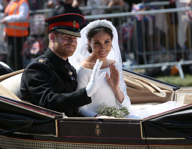 The new Duke and Duchess of Sussex ride in an Ascot Landau through Windsor before cheering crowds (Aaron Chown/PA)
