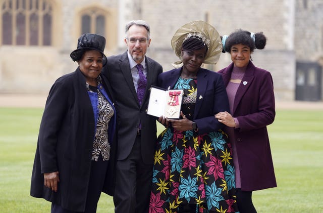 Dame Margaret Aderin-Pocock (2nd right) poses for a photograph with her daughter Lori (right), husband Dr Martin Pocock (2nd left) and mother Carol Phillips (left) after being made a Dame Commander of the British Empire during an investiture ceremony at Windsor Castle, Berkshire 