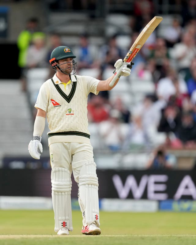 Travis Head raises his bat following his half-century