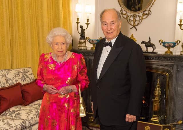 Queen Elizabeth II hosting a reception for the late Aga Khan IV in the White Drawing Room at Windsor Castle
