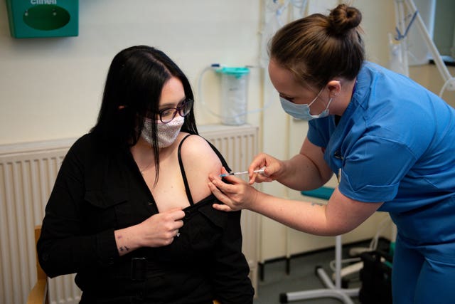 Elle Taylor, 24, an unpaid carer from Ammanford, receives an injection of the Moderna vaccine administered by nurse Laura French, at the West Wales General Hospital in Carmarthen