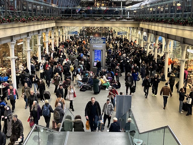 Passengers wait at the Eurostar entrance in St Pancras International station, London