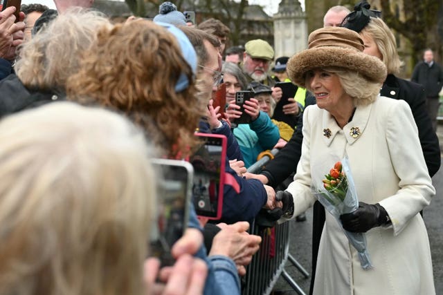 Camilla wearing a faux-fur rimmed hat collects bouquets as she meets wellwishers after the Royal Maundy Service