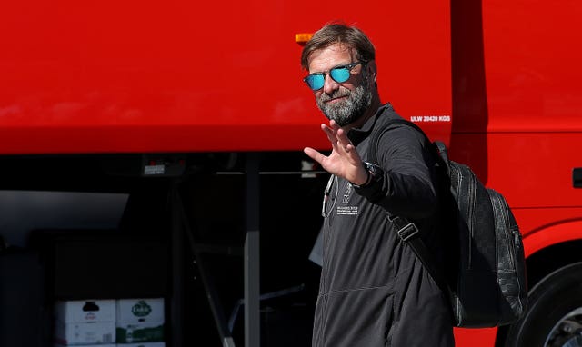 Manager Jurgen Klopp waves to photographers as he heads for the team bus